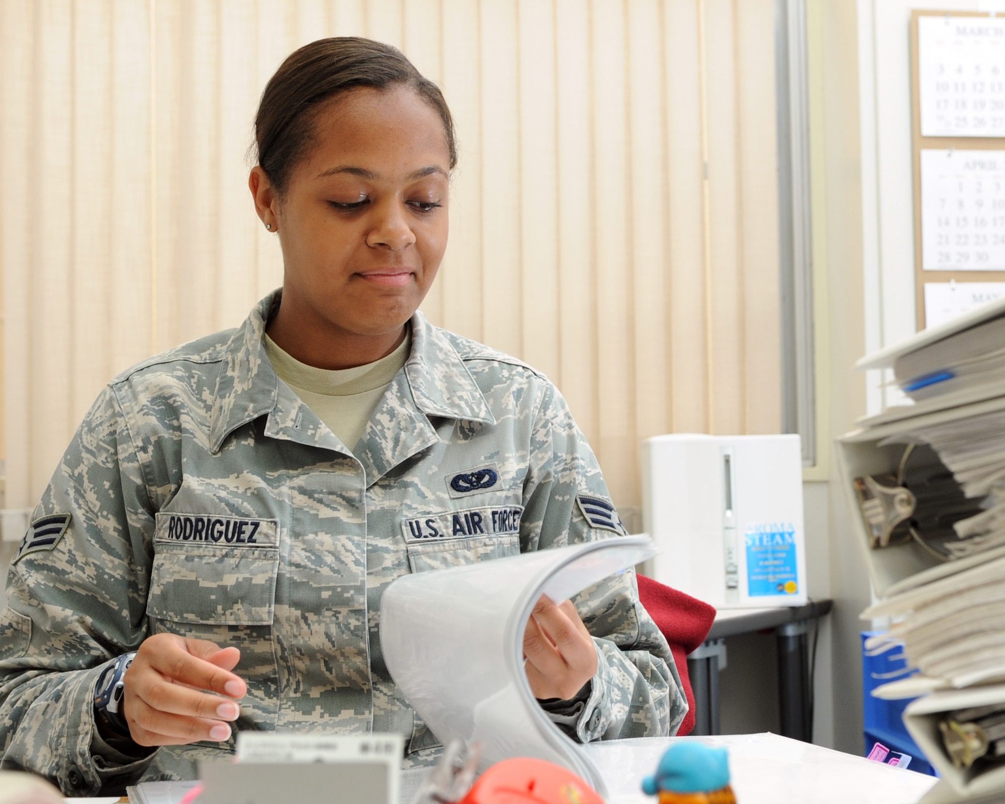 YOKOTA AIR BASE, Japan -- Senior Airman Victoria Rodriguez, 374th Civil Engineer Squadron administrative specialist, sorts paperwork in binders May 22, 2013, at Yokota Air Base, Japan. Rodriguez conducts training for new facility managers to Yokota. (U.S. Air Force photo by Airman 1st Class Desiree Economides/released)