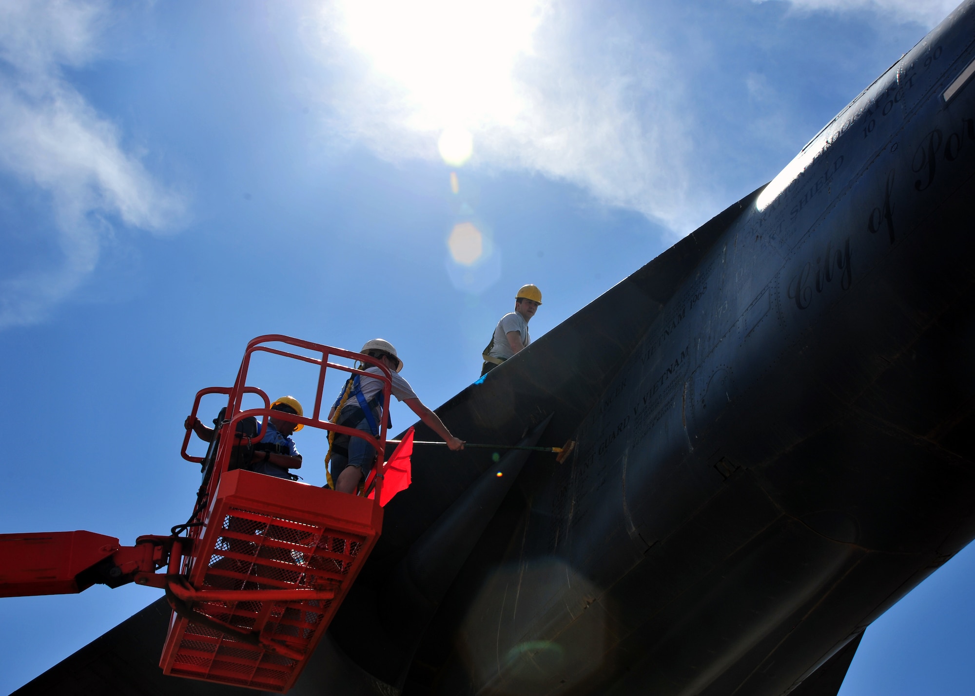 Members of the Airman Leadership School at Cannon Air Force Base, N.M., are hoisted off the ground to polish an F-111 Aardvark static display during a community clean-up in Portales, N.M., May 18, 2013. The project was intended to foster good community relations and increase camaraderie amongst ALS students. (U.S. Air Force photo/Senior Airman Whitney Tucker)