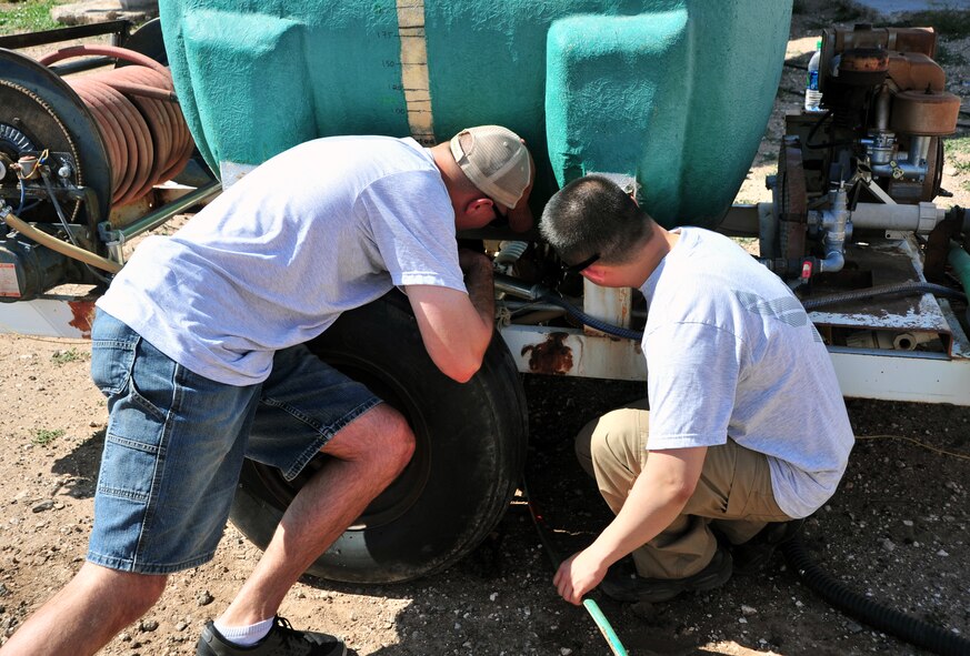 Members of the Airman Leadership School at Cannon Air Force Base, N.M., repair a valve during a community clean-up in Portales, N.M., May 18, 2013. The project was intended to foster good community relations and increase camaraderie amongst ALS students. (U.S. Air Force photo/Senior Airman Whitney Tucker)