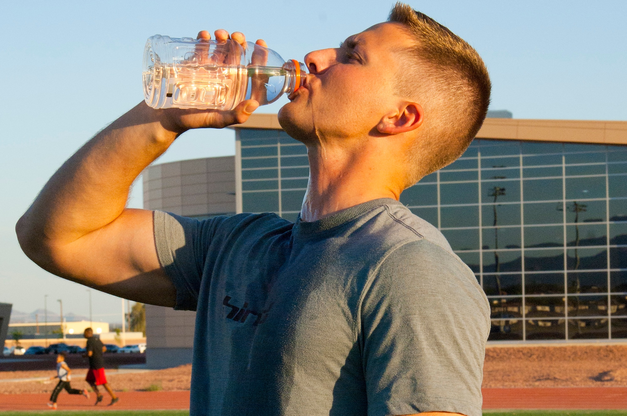 Airman 1st Class Andrew Casperite, 57th Maintenance Squadron munitions systems apprentice, drinks water after finishing a work out at the Warrior Fitness Center track May 21, 2013, at Nellis Air Force Base, Nev. Staying hydrated is key to preventing heat related injuries and maintaining peak performance. (U.S Air Force photo by Staff Sgt. Gregory Brook)