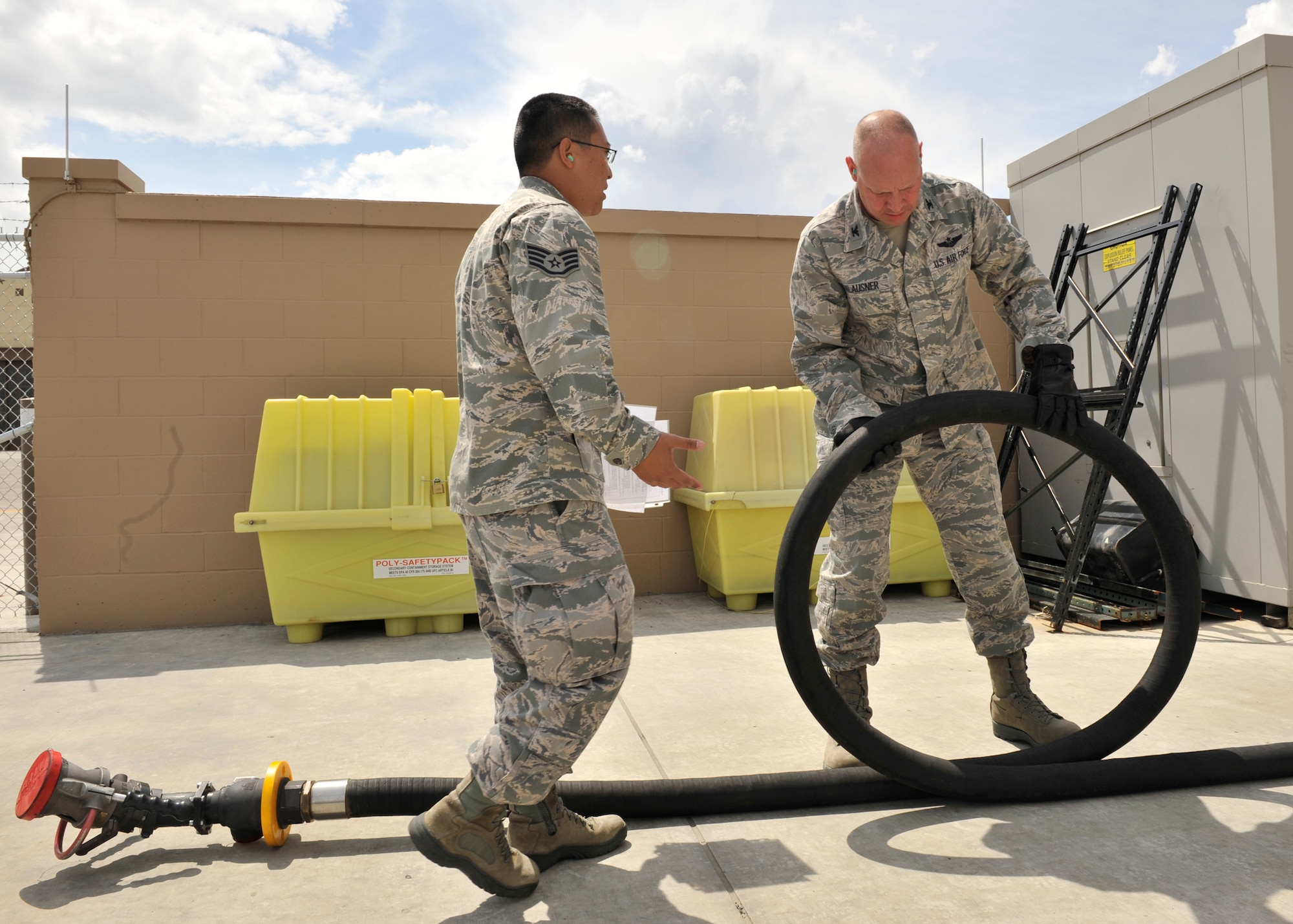 Staff Sgt. Joshua Nakao, 92nd Logistics Readiness Squadron preventative maintenance noncomissioned officer in charge, inspects a fuel hose from an R11 fuel truck with Col. Konrad Klausner, 92nd Mission Support Group commander, at Fairchild Air Force Base, Wash. May 17, 2013. The colonel will periodically participate in the work his Airmen perform to better understand the effort put into the mission. (U.S. Air Force photo by Staff Sgt. Michael Means/Released)