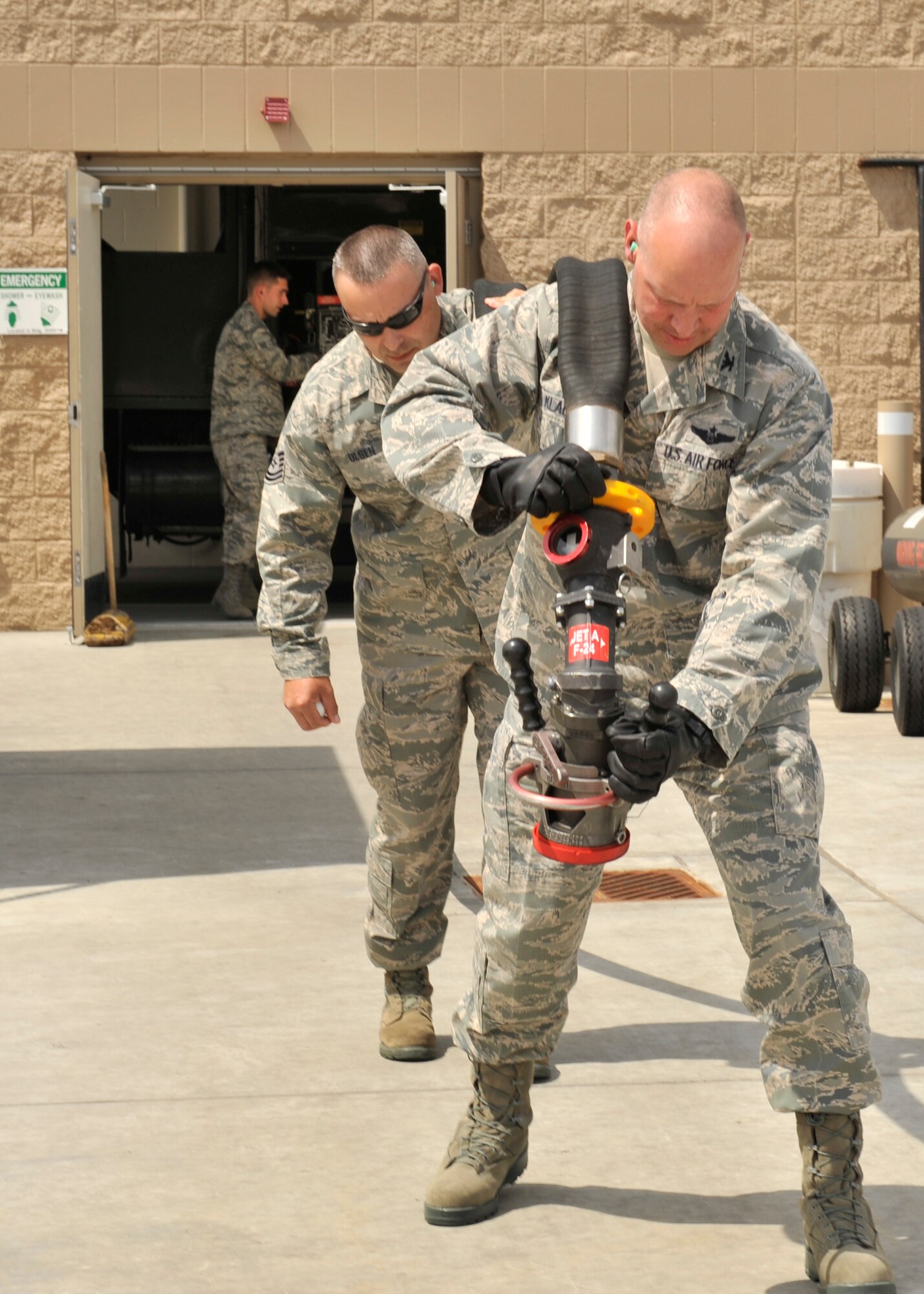 Tech. Sgt. John Olsen, 92nd Logistics Readiness Squadron fuels distribution noncommisioned officer in charge and Col. Konrad Klausner, 92nd Mission Support Group carry a fuel hose from an R11 fuel truck for inspection at Fairchild Air Force Base, Wash. May 17, 2013. The colonel will periodically participate in the work his Airmen perform to better understand the effort put into the mission. (U.S. Air Force photo by Staff Sgt. Michael Means/Released)