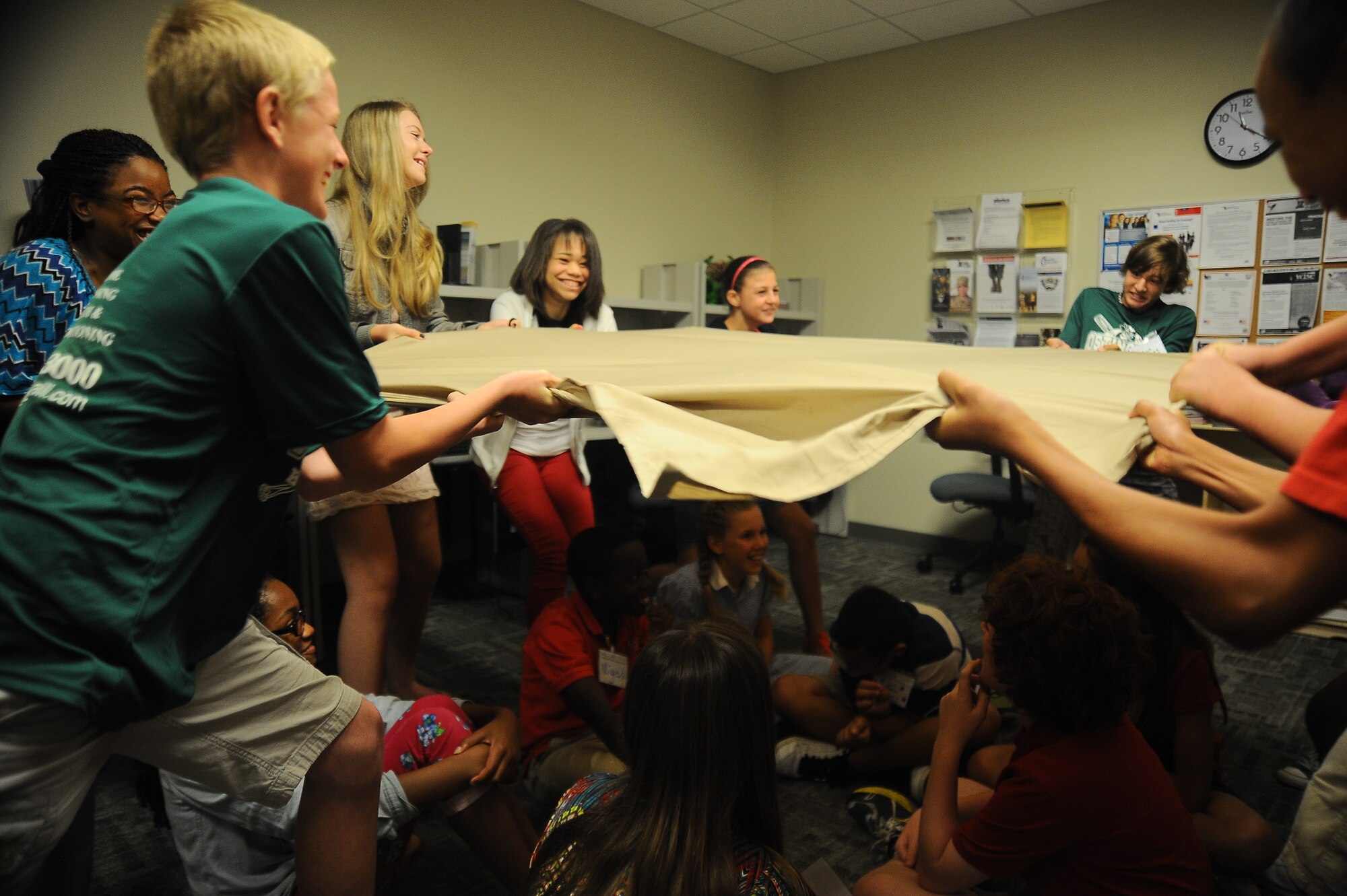 Students participate in a Power Blanket activity during a Junior Student to Student (JS2S) training May 20, 2013, on MacDill Air Force Base, Fla. The Power Blanket activity is designed to emulate how students can protect one another against bullying; the blanket provided cover and security for the simulated new students below. (U.S. Air Force photo by Senior Airman Michael Ellis/Released)