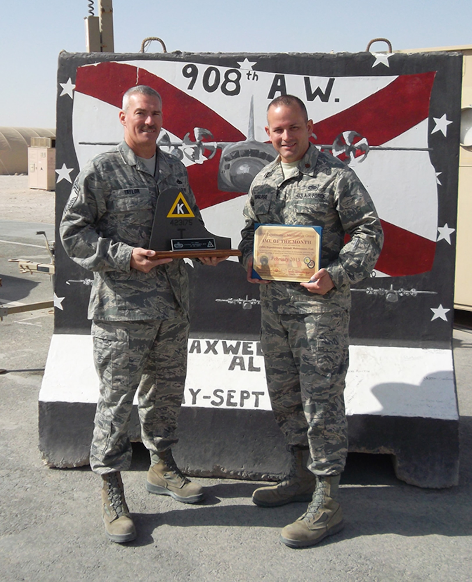 Chief Master Sgt. Greg Taylor and Maj. Brad Douglass proudly display the Aircraft Maintenance Unit of the Month Award.