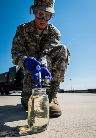 Airman 1st Class Chaz Wise, 628th Logistics Readiness Squadron Fuels technician, drains fuels from a filter, which was used to test for water May 9, 2013, at Joint Base Charleston – Air Base, S.C. Jet fuel is passed through a filter which is then placed under an ultraviolet light that will turn the filter green if water is found in the fuel. (U.S. Air Force photo/ Senior Airman Dennis Sloan)