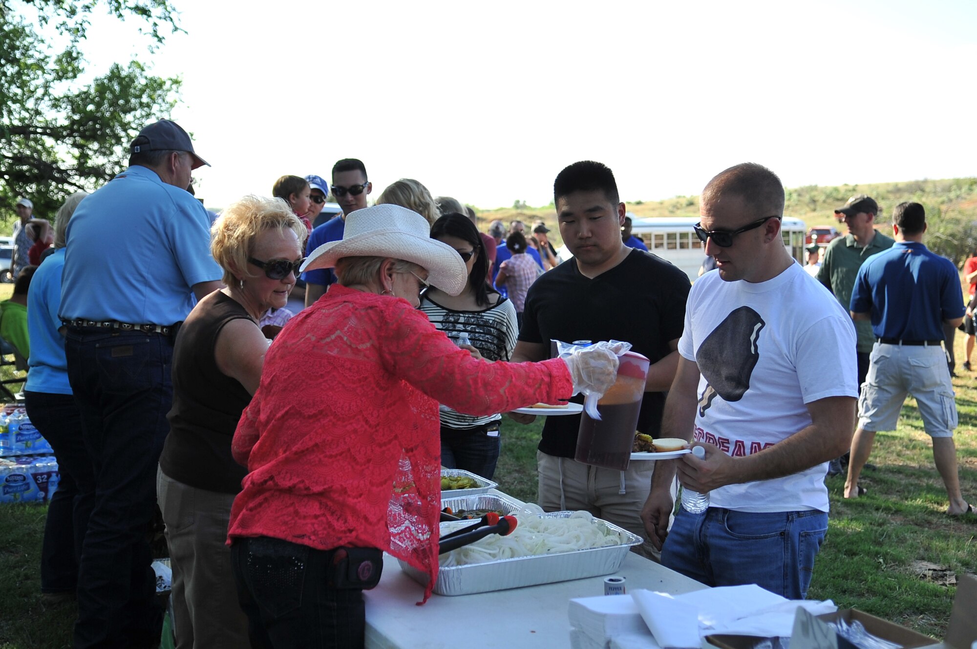 NINE-MILE SPRING, Okla. – Community members from Altus, Okla. serve BBQ to Altus Air Force Base Airmen and family members during the Committee of 100 welcoming dinner, May 20, at Nine-Mile Spring. The Committee of 100 is made up of local community members and hosts Altus AFB newcomers each quarter as a local outreach program. (U.S. Air Force photo by Senior Airman Dillon Davis/Released)