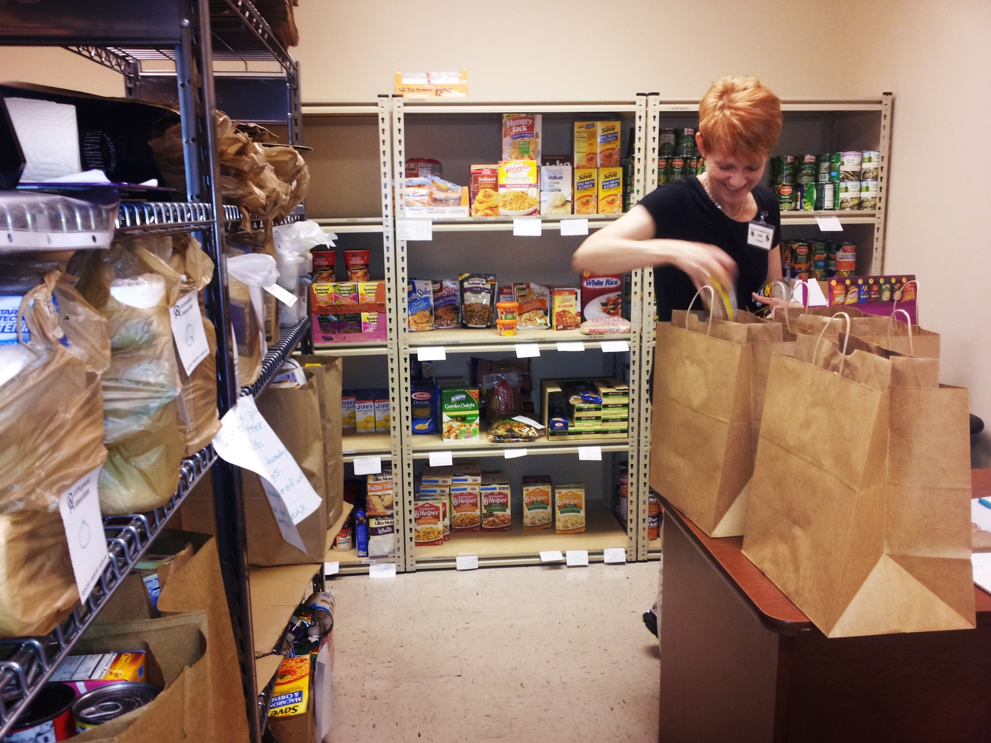 Courtney Engle fills bags in the food pantry at the Airman and Family Readiness Center on Tinker Air Force Base. The food pantry, normally open for active duty military only has been opened for all members of Team Tinker who were affected after an F5 tornado tore through the nearby town of Moore, leaving more than 340 military and civilian members of Team Tinker without homes or temporarily displaced.  (Air Force photo by Micah Garbarino)