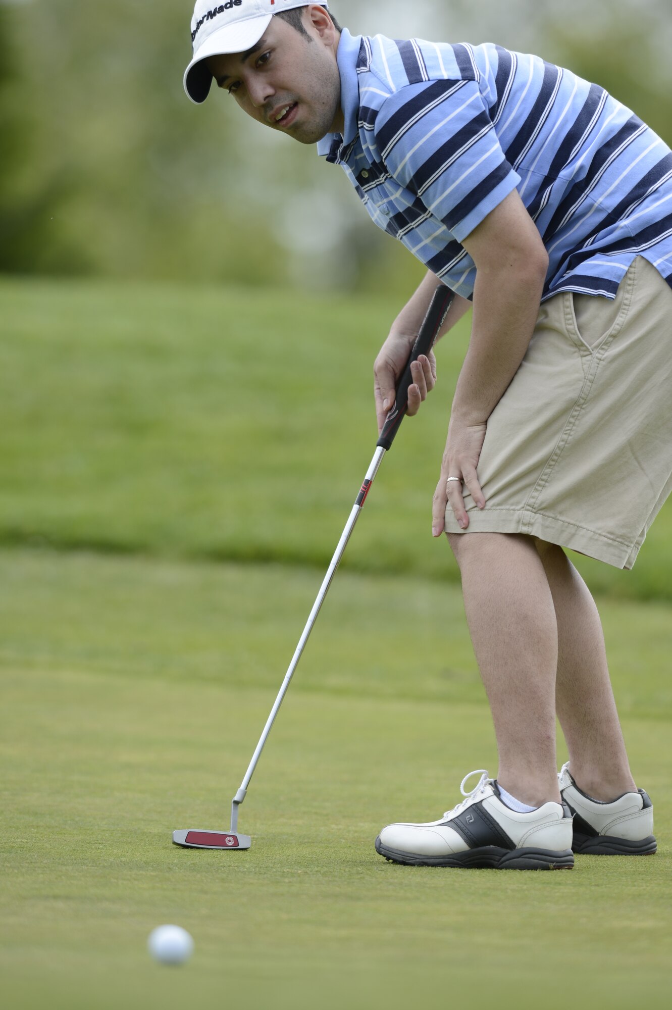 Staff Sgt. James Bray, 436th Airlift Wing Command Chief Master Sgt. Executive Assistant, watches with anticipation as his golf ball rolls toward the hole during a game at Jonathon's Landing Golf Course, near Dover Air Force Base, Del. on May 15th, 2013. Key military members from Dover AFB were paired with local civic and business leaders for the Bluesuiters Golf Tournament as part of Dover's robust community outreach program. (U.S. Air Force photo/Greg L. Davis)