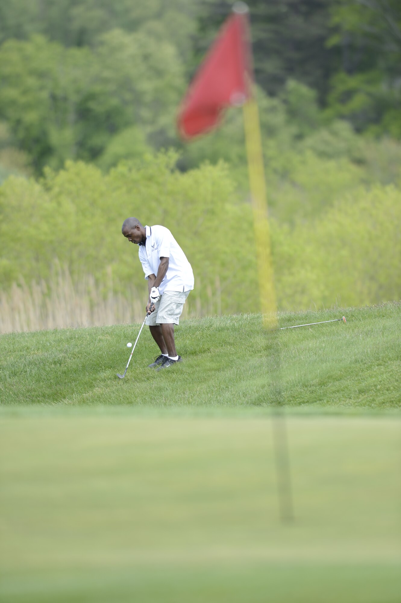 First Lieutenant Anthony Richardson, 436th Airlift Wing Public Affairs Officer, hits a golf ball toward the hole on Jonathon's Landing Golf Course, near Dover Air Force Base, Del. on May 15th, 2013. Key military leaders from Dover AFB were paired with local civic and business leaders for the Bluesuiters Golf Tournament as part of Dover's robust community outreach program. (U.S. Air Force photo/Greg L. Davis)