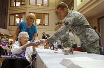 MINOT, N.D. -- An Airman from the 791st Missile Security Forces Squadron offers ice cream to a resident of Minot Trinity Homes, May 18. The Ice Cream Social was the first ever social hosted by the Friends of Veterans organization, a 791st MSFS association. (U.S. Air Force photo/Senior Airman Jose L. Hernandez)