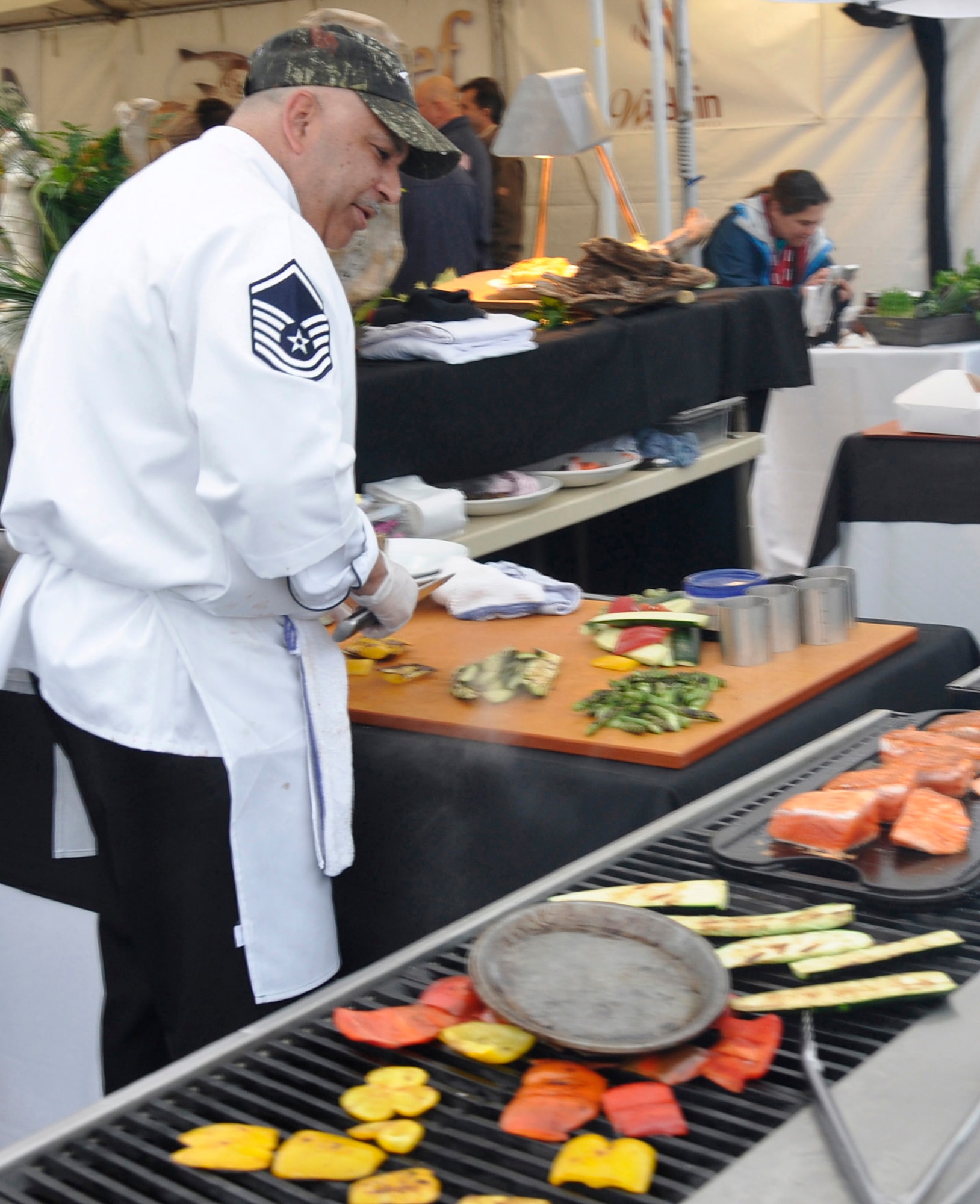 Master Sgt. Robert Shulman, 446th Force Support Squadron sustainment
services flight manager, McChord Field, Wash., demonstrates culinary skill
during Alaska Air Cargo's annual Copper Chef Cook-Off May 17 in Seattle.
Shulman prepared his balsamic and agave nectar glazed Copper River salmon recipe for judges and spectators, earning him a silver
medal in the competition. (U.S. Air Force photo by 1st Lt. Lori Fiorello)
