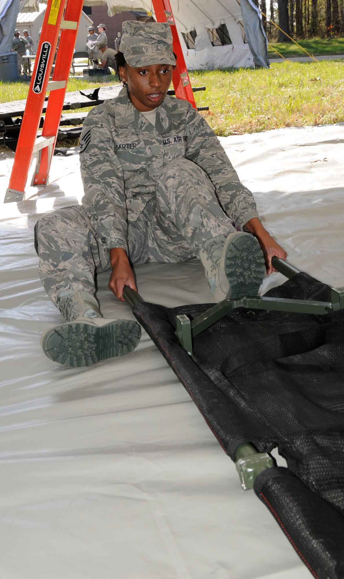 Staff Sgt. Christin Carter, 192nd Medical Group Bio-environmental specialist, opens a patient carrier during an exercise at Langley Air Force Base, April 7.  192nd MDG is one of four elements that is part of the Virginia National Guard’s special response force for Chemical Biological Radiological Nuclear High Yield Explosive Response Force Package, known as the CERFP (pronounced “surf-p”).  The CERFP can conduct tasks associated with incident management, urban search and rescue, mass causality decontamination, technical decontamination, medical triage and treatment and fatality search and recovery.  (U.S. Air National Guard photo by Master Sgt. Carlos J. Claudio/Released)