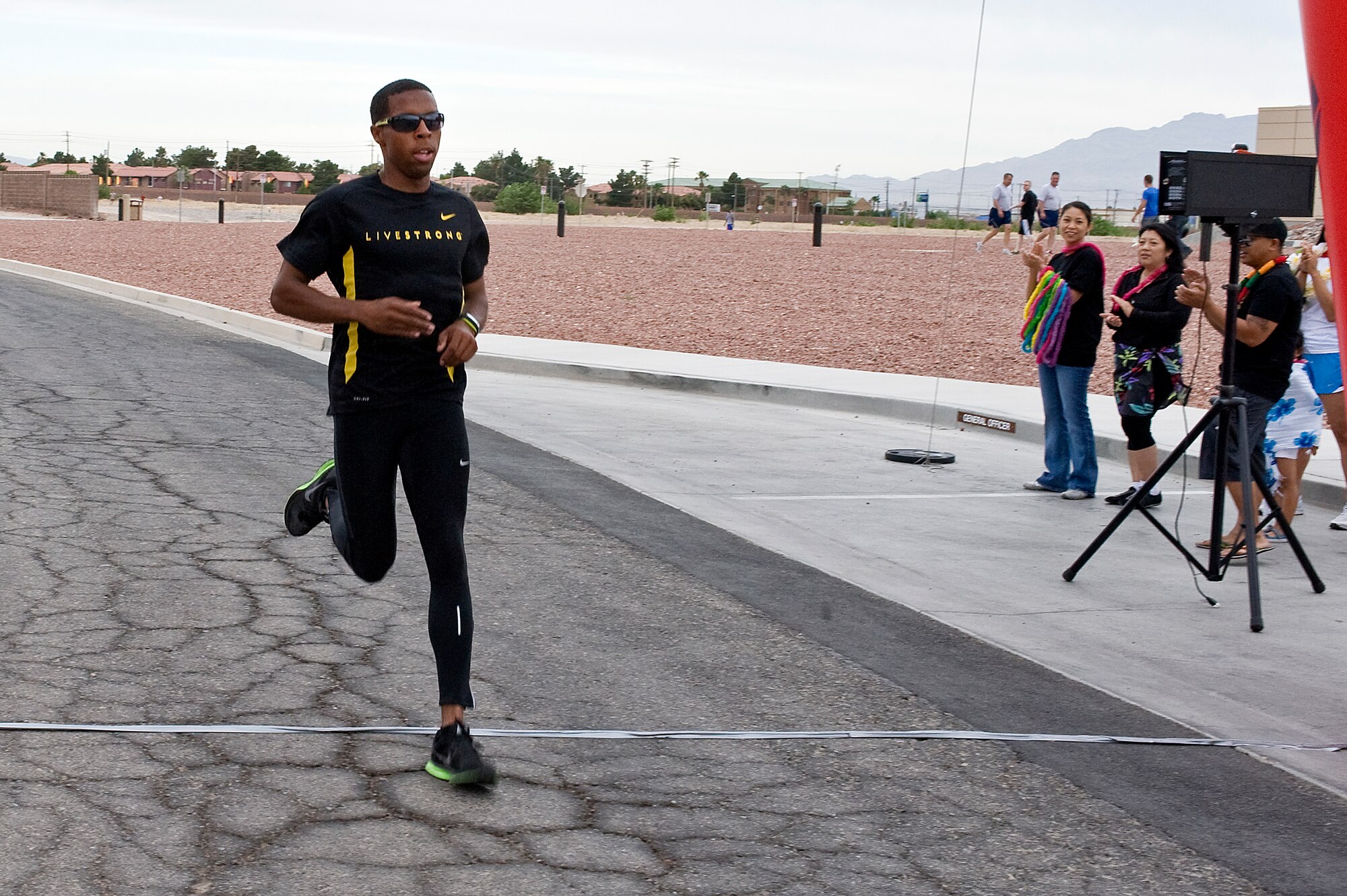Brian Beachum, 757th Aircraft Maintenance Squadron crew chief, crosses the finish line as the first place runner during the Resiliency Day 5 kilometer race May 17, 2013, at Nellis Air Force Base, Nev. Beachum, who is training for the Air Force Marathon, finished with a time of 18:10. (U.S. Air Force photo by Senior Airman Matthew Lancaster)