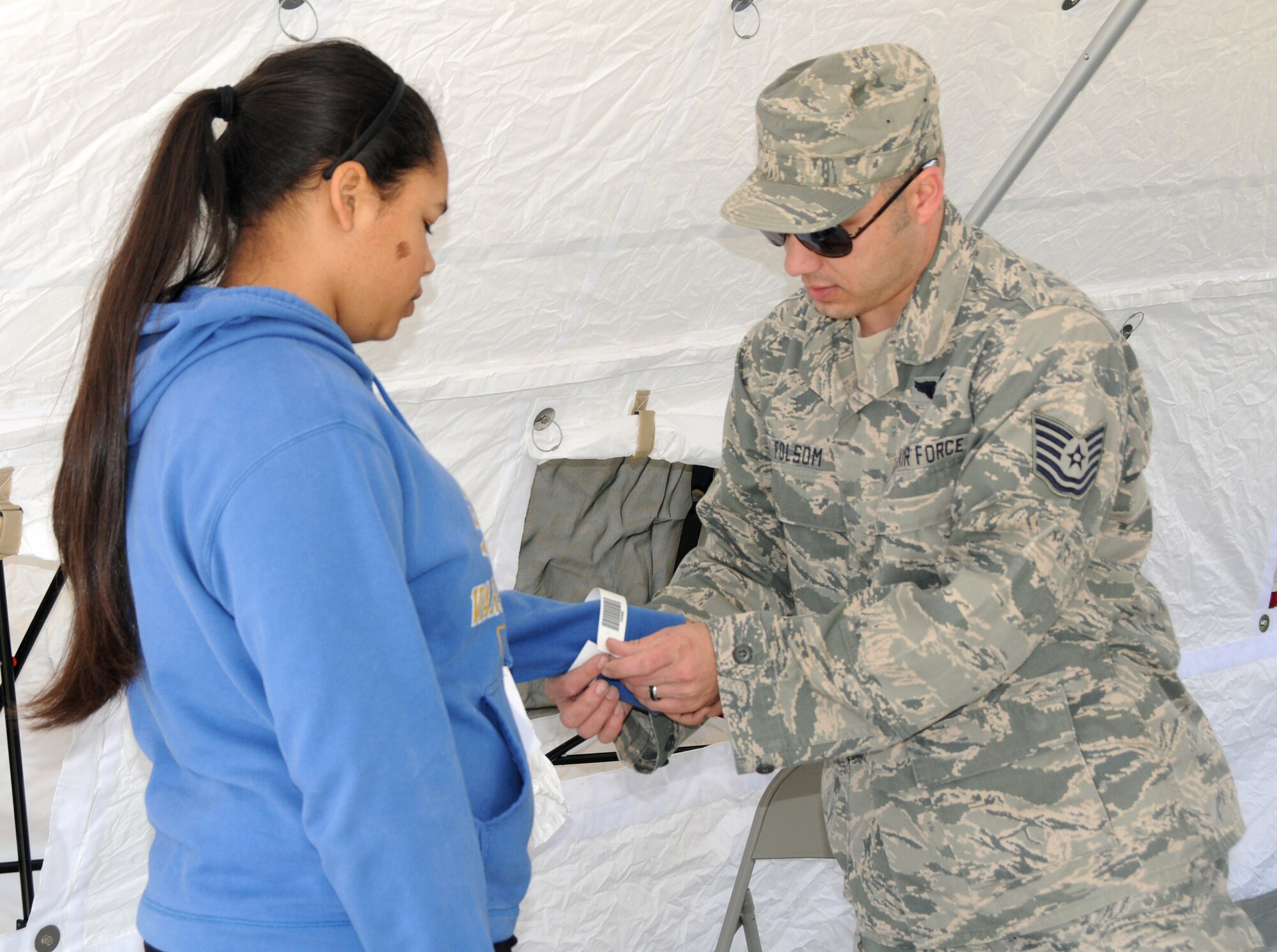 Tech. Sgt. James Folsom, a member of the 192nd MDG, assesses a patient with simulated injuries to be escorted for treatment during a training exercise conducted at Langley Air Force Base, April 7.  192nd MDG is one of four elements that is part of the Virginia National Guard’s special response force for Chemical Biological Radiological Nuclear High Yield Explosive Response Force Package, known as the CERFP (pronounced “surf-p”).  The CERFP can conduct tasks associated with incident management, urban search and rescue, mass causality decontamination, technical decontamination, medical triage and treatment and fatality search and recovery.  (U.S. Air National Guard photo by Airman First Class Johnisa B. Roberts/Released) 