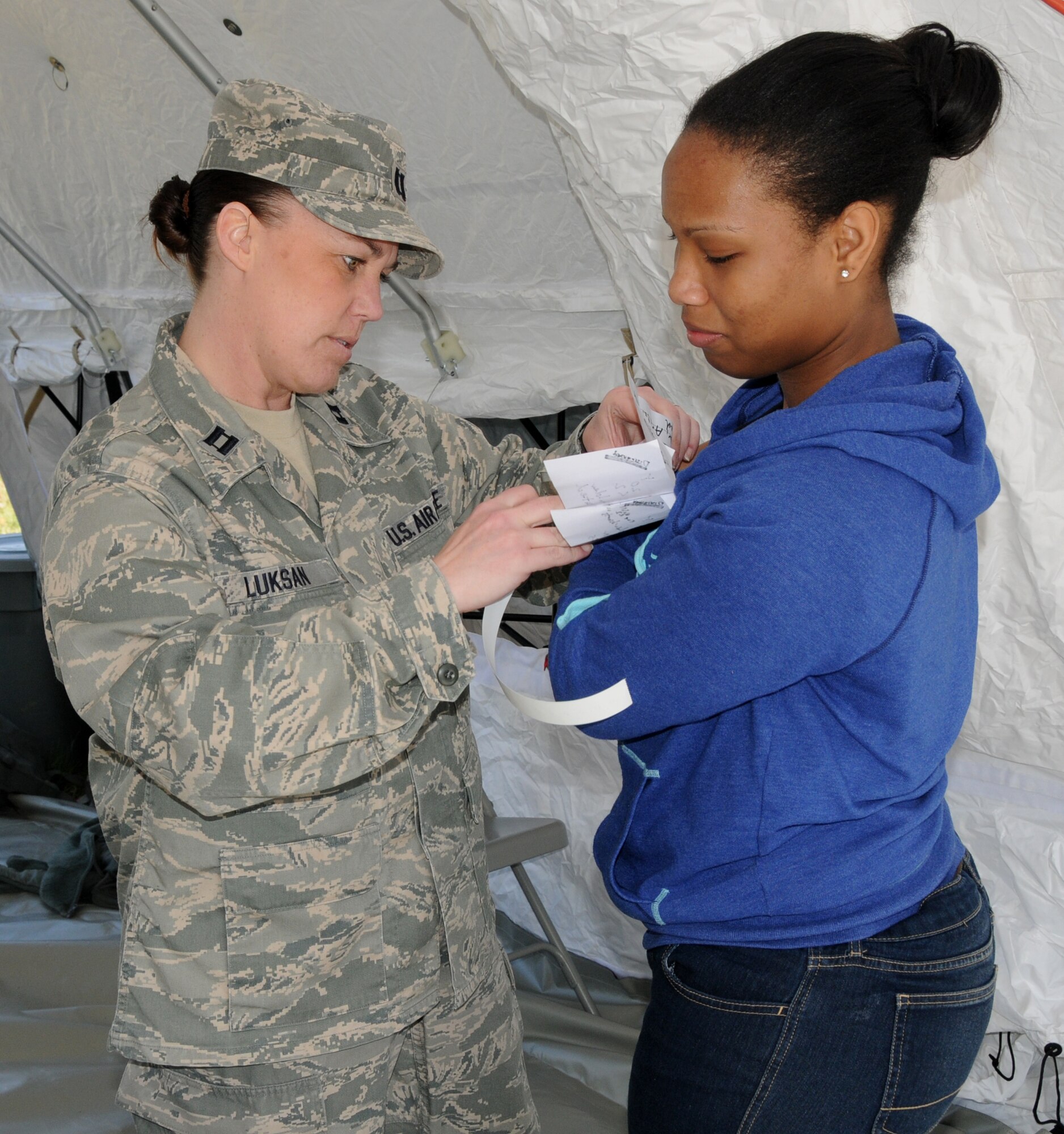 Capt. Rocki Luksan, 192nd Fighter Wing Medical Group nurse, assesses a patient with simulated injuries for treatment during a training exercise conducted at Langley Air Force Base, April 7.  The 192nd MDG uses the triage method to assess how severe victims are injured during an emergency and then directs them to the appropriate area for treatment.  (U.S. Air National Guard photo by Airman First Class Johnisa B. Roberts/Released) 