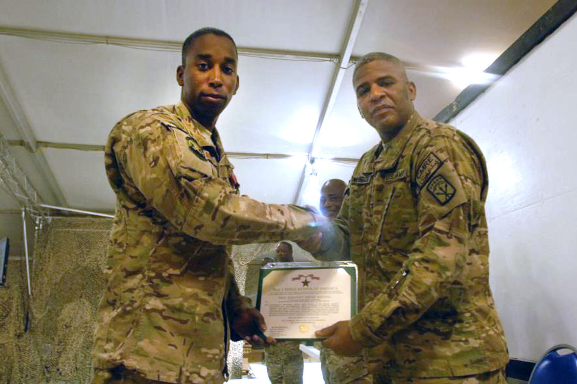 SOUTHWEST ASIA -- Staff Sgt. Johnathan McEachin is presented the Bronze Star by Col. Douglas McBride, 593rd Sustainment Brigade commander, during a ceremony here March 3. McEachin received the medal for contract management duties on 30 contracts totaling more than $100 million in labor augmentation among other meritorious service. (Courtesy photo)