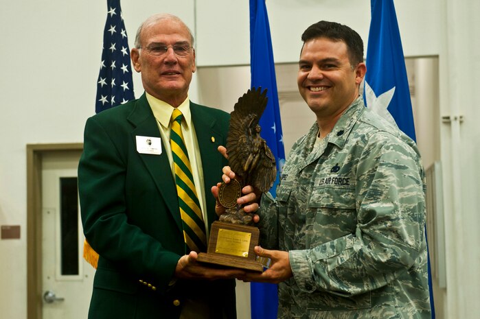 MG (ret) Bruce Smith, Chairman, Order of Daedalians Foundation, presents Lt. Col. Gabriel Lopez, 99th Logistics Readiness Squadron commander, with the Daedalian Maj. Gen. Warren R. Carter Logistics Effectiveness Award during a ceremony May 21, 2013, at Nellis Air Force Base, Nev. The 99th LRS competed against 219 other LRS organizations across the U.S. Air Force and was chosen as the best LRS in the Air Force. (U.S. Air Force photo/Senior Airman Brett Clashman)