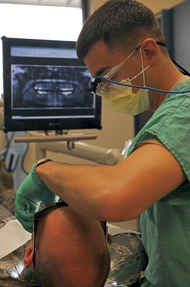 Capt. Michael Lueck, 375th Dental Squadron dental resident, prepares a patient to recieve his temporary crown May 16, 2013 at Scott Air Force base, Ill.  A temporary crown is shaped by the dentist to form a tooth shape that protects the prepared tooth, prevent damage to the gums, and diguises the prepared tooth until final restoration. (U.S. Air Force photo/Senior Airman Divine Cox)