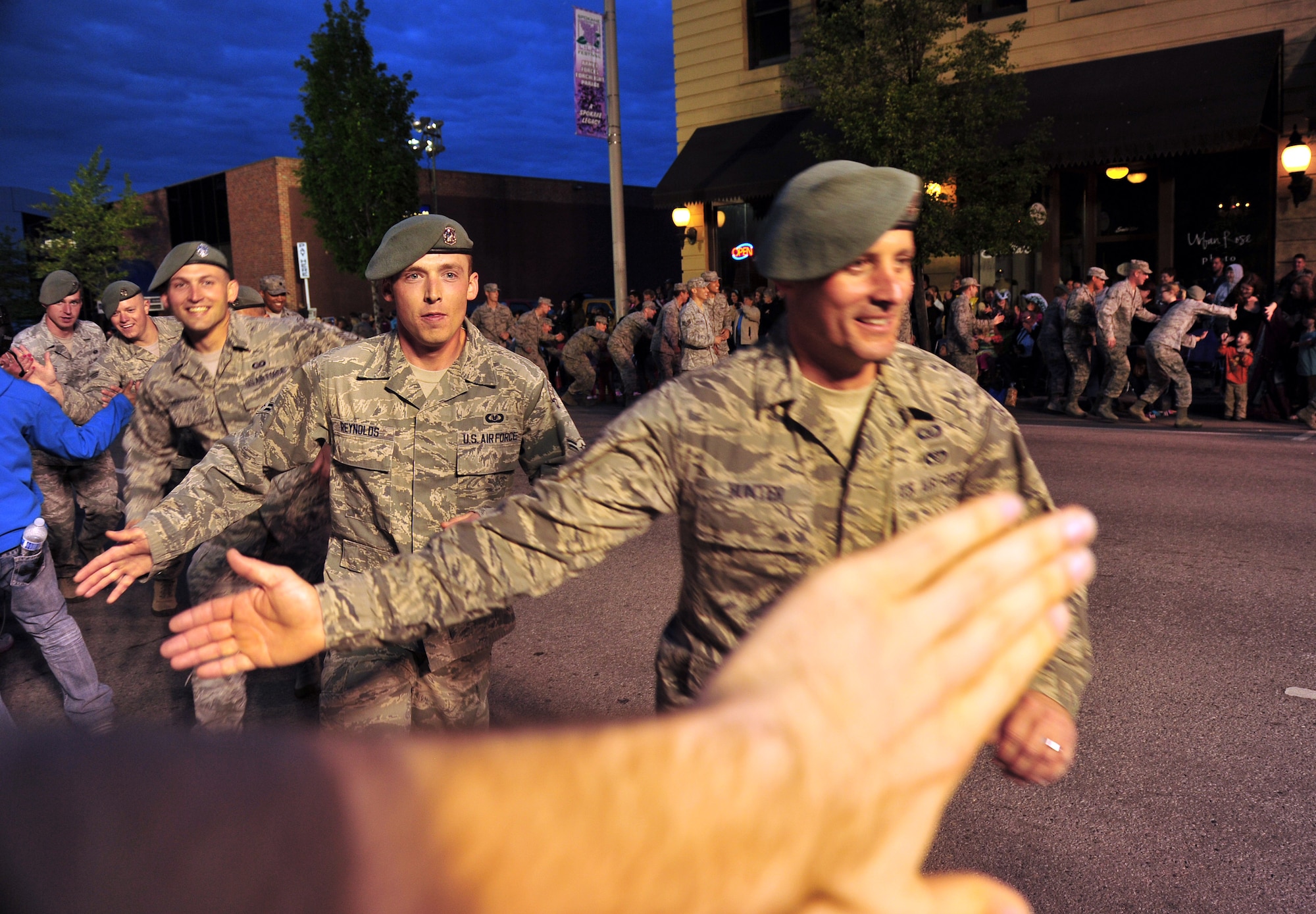 Airmen from the 336th Training Group break formation to give high fives to spectators during the Lilac Festival’s Armed Forces Torchlight Parade in Spokane, Wash., May 18, 2013. The parade is considered the nation’s largest Torchlight Parade on Armed Forces Day. (U.S. Air Force photo by Senior Airman Taylor Curry)