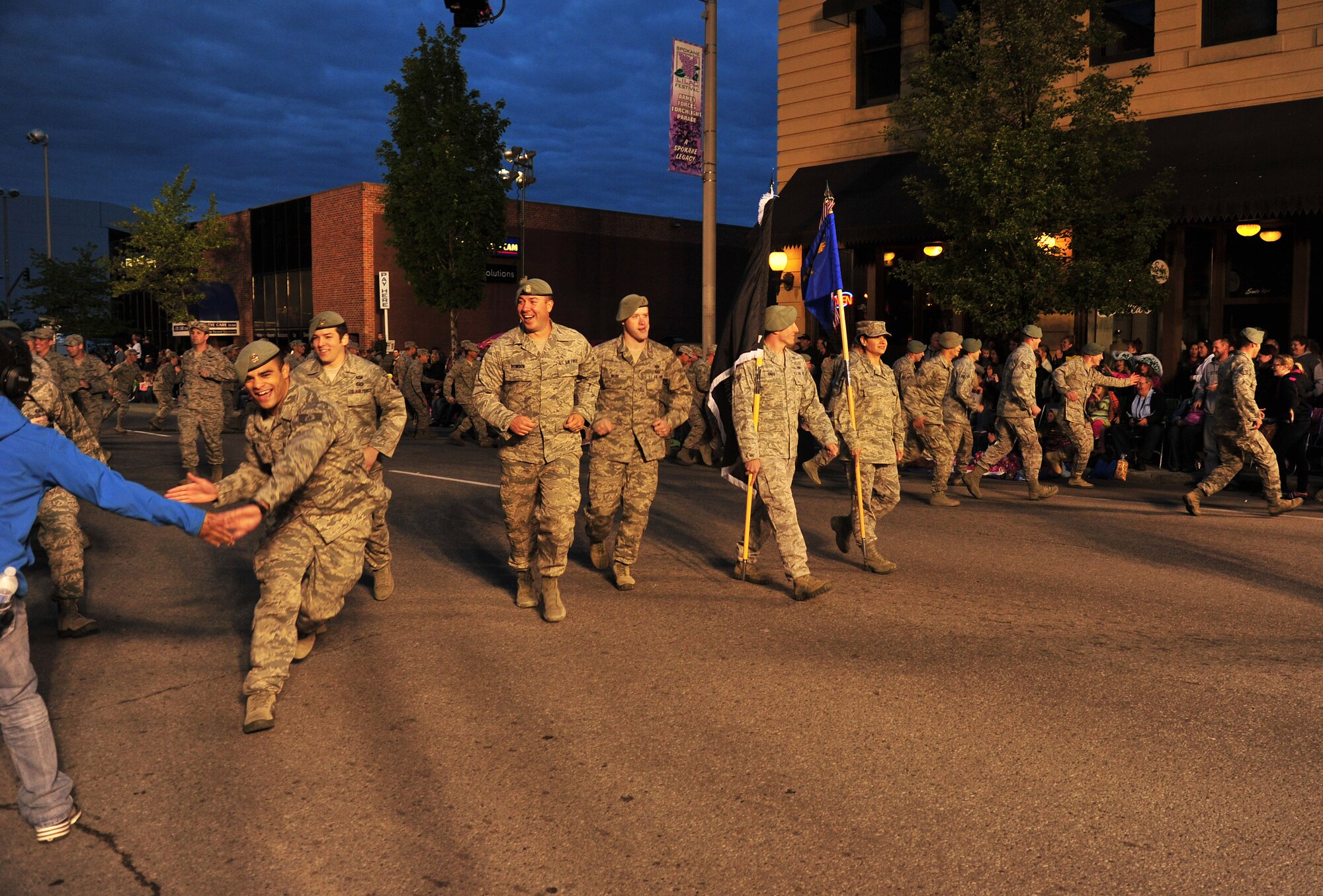 Airmen from the 336th Training Group break formation to give high fives to spectators during the Lilac Festival’s Armed Forces Torchlight Parade in Spokane, Wash., May 18, 2013. The parade is considered the nation’s largest Torchlight Parade on Armed Forces Day. (U.S. Air Force photo by Senior Airman Taylor Curry)