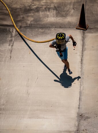 A 628th Civil Engineer Squadron crew chief pulls a fire hose over his shoulder while running with his teams baton during the Police Week Guns and Hoses competition May 15, 2013, at Joint Base Charleston – Air Base, S.C. The 628th Security Forces Squadron hosted events for National Police Week including the "Guns and Hoses" fitness challenge, a shooting competition, chili cook-off and a retreat ceremony. National Police Week recognizes the services and sacrifices of U.S. law enforcement personnel. (U.S. Air Force photo/ Senior Airman Dennis Sloan)