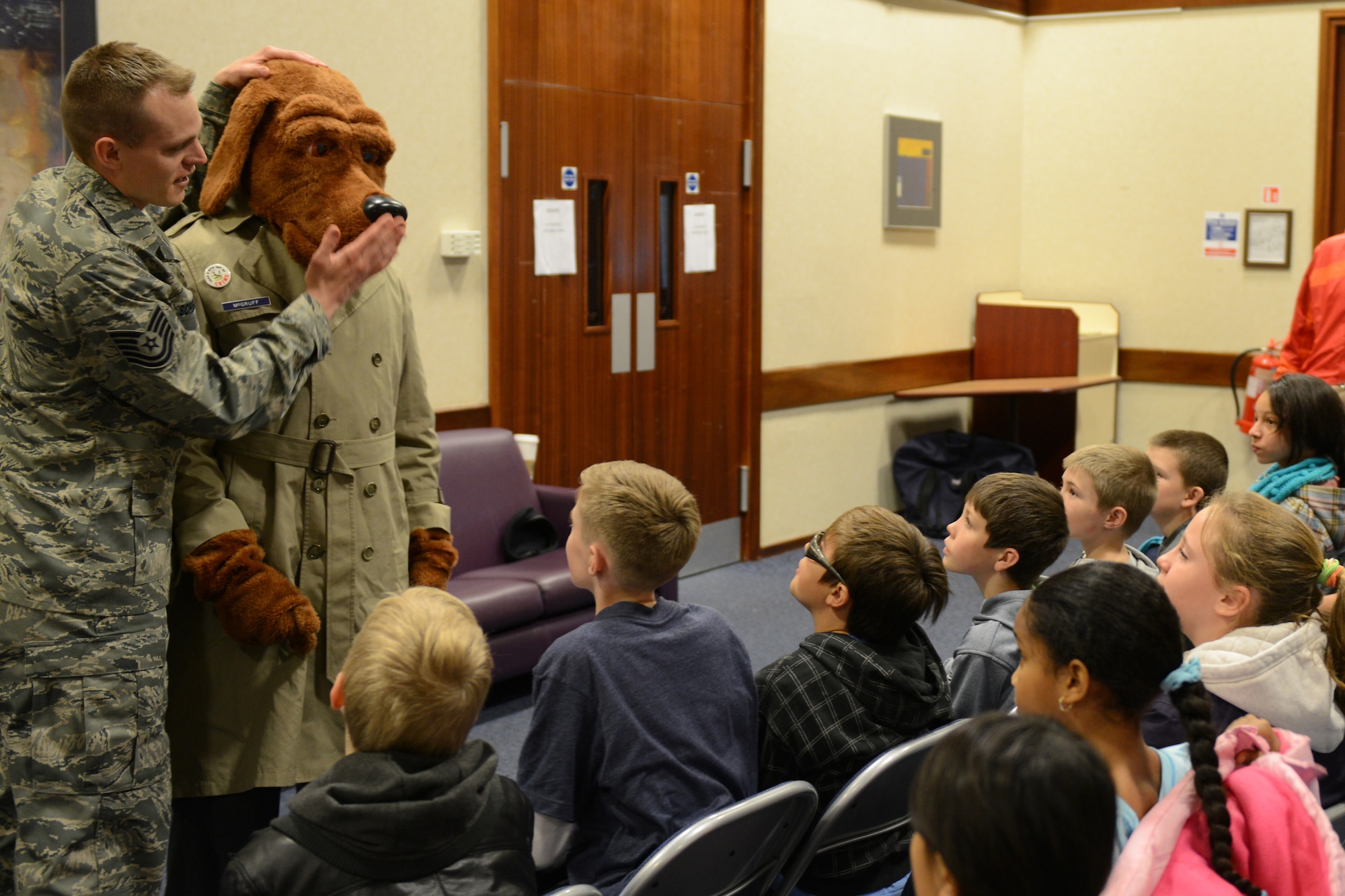 RAF CROUGHTON, United Kingdom – Tech. Sgt. Arthur Scruggs, 422nd Security Forces Squadron, asks children from Croughton Elementary School if they know what McGruff uses his nose for. McGruff made an appearance during a stranger danger briefing during Police Week at RAF Croughton. The correct answer is to sniff out crime. (U.S. Air Force photo by Tech. Sgt. Chrissy Best)