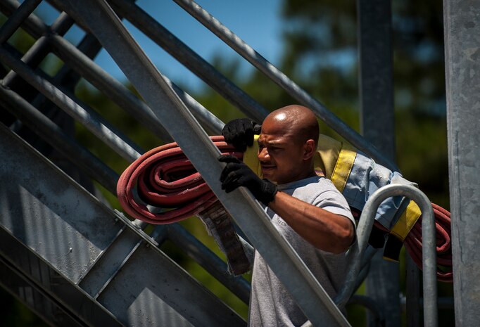 Staff Sgt. Leatrice Robinson, 628th Civil Engineer Squadron crew chief, practices carrying a fire hose up a five-story tower before a during the Police Week Guns and Hoses competition May 15, 2013, at Joint Base Charleston – Air Base, S.C. The 628th Security Forces Squadron hosted events for National Police Week including the "Guns and Hoses" fitness challenge, a shooting competition, chili cook-off and a retreat ceremony. National Police Week recognizes the services and sacrifices of U.S. law enforcement personnel. (U.S. Air Force photo/ Senior Airman Dennis Sloan)