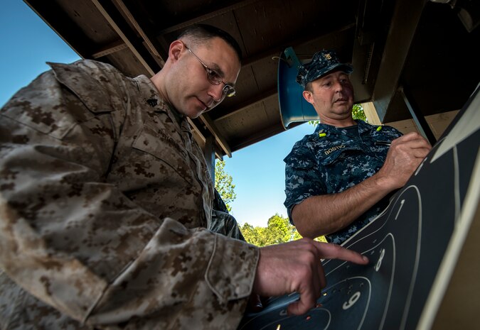 Marine Corps Sgt. Cody Prickett, Naval Consolidated Brig Charleston security forces member, reviews his target sheet while Master Chief Petty Officer Charles Bostic, NCBC Command Master Chief notes his score during the Security Forces Shooting Competition May 15, 2013, at Joint Base Charleston – Air Base, S.C. In honor of National Police Week, JB Charleston held a Guns and Hoses competition, Military Working Dog demonstration a Retreat ceremony at the JB Charleston - Air Base Flagpole. (U.S. Air Force photo/ Senior Airman Dennis Sloan)
