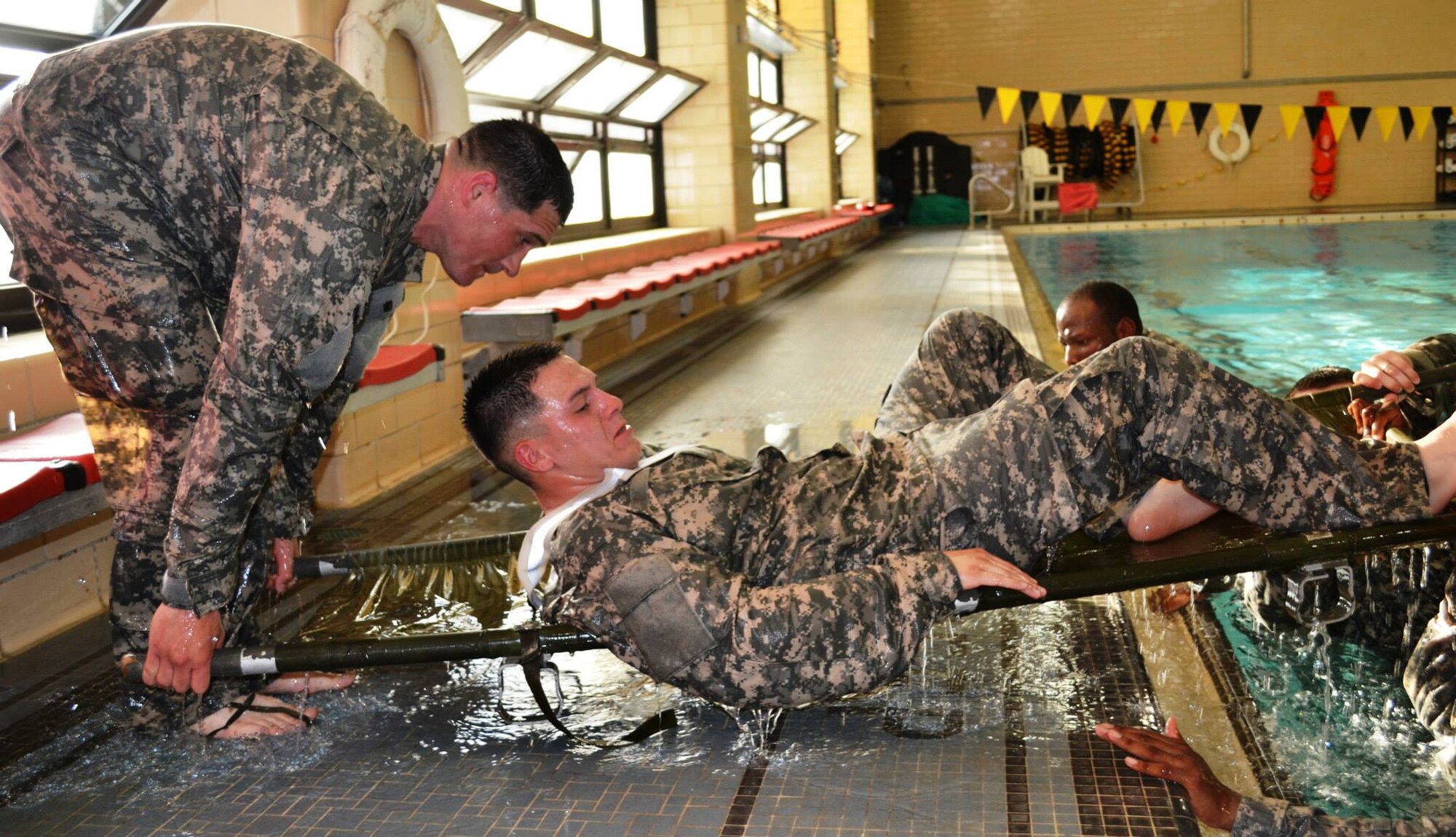 Soldiers from the 10th Transportation Battalion, 7th Sustainment Brigade carry a simulated casualty across an Olympic-sized swimming pool during a pre-dawn squad fitness competition at Fort Eustis, Va., May 17, 2013. The 97th Trans. Company won the competition, earning the coveted “Waterborne Belt.” (U.S. Army photo by Sgt. 1st Class Brian G. Rhodes/Released)