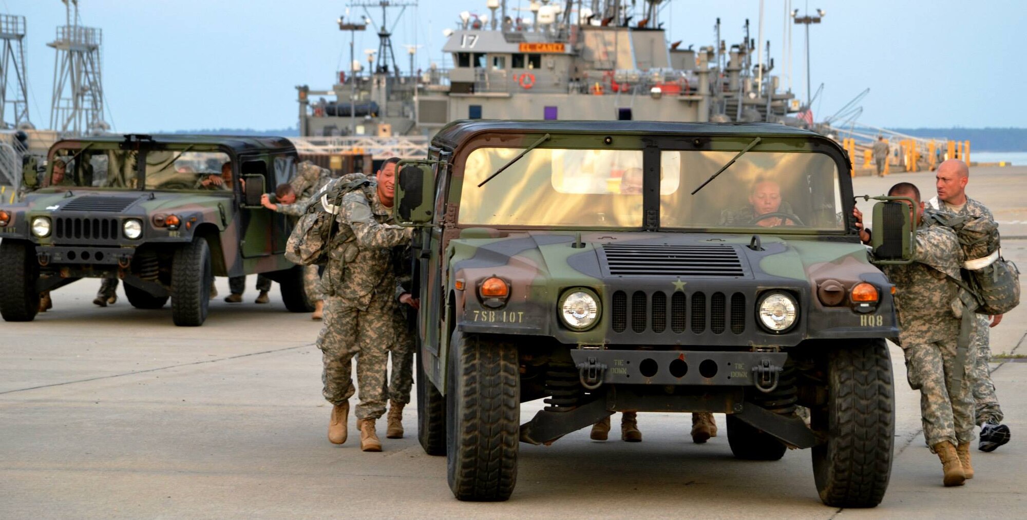 Soldiers from the 10th Transportation Battalion, 7th Sustainment Brigade work together to push Humvees on a 100-yard cone course during a pre-dawn squad fitness competition at Fort Eustis, Va., May 17, 2013. The Humvee push was one of several fast-paced, team-oriented events in the competition, which pitted companies against one another to earn the “Waterborne Belt.” (U.S. Army photo by Sgt. 1st Class Brian G. Rhodes/Released)