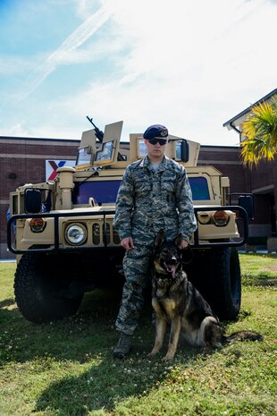 Staff Sgt. Kyle Shaughnessy, 628th Security Forces Squadron military working dog handler, and MWD Jaga, a 3-year-old German Shepherd Dog assigned to the 628th Security Forces Squadron stand in front of a humvee   before performing a canine demonstration May 16, 2013, at Joint Base Charleston, S.C. The JB Charleston commander and 437th Airlift Wing commander judged the chili cook-off. The 628th Security Forces Squadron hosted events including the "Guns and Hoses" fitness challenge, a shooting competition, chili cook-off and a retreat ceremony. National Police Week recognizes the services and sacrifices of U.S. law enforcement personnel. (U.S. Air Force photo/Staff Sgt. Rasheen Douglas)