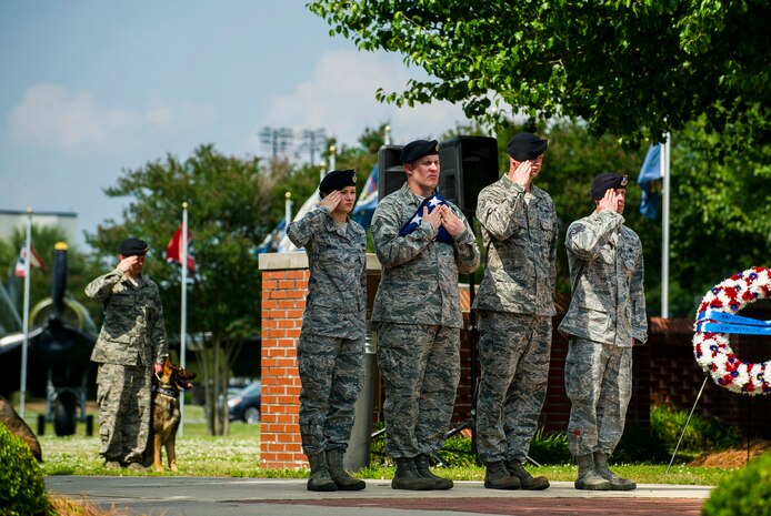 Tech. Sgt. Shaun Horn, 628th Security Forces Squadron flight chief, holds the United States’ flag while Staff Sgt. Adam Thompson, 628th SFS Combat Arms Training and Maintenance instructor, Senior Airman Jonathan Breed, 628th SFS armorer, and Airman 1st Class Heather Miller, 628th SFS patrolman, salute during the Police Week Retreat ceremony May 17, 2013, at Joint Base Charleston - Air Base, S.C. The 628th Security Forces Squadron hosted events including the "Guns and Hoses" fitness challenge, a shooting competition, chili cook-off and a retreat ceremony. National Police Week recognizes the services and sacrifices of U.S. law enforcement personnel. (U.S. Air Force photo/ Senior Airman George Goslin)
