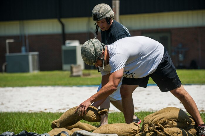 Members of the 628th Security Forces Squadron team build a defensive firing position out of sandbags during the Police Week Guns and Hoses competition May 15, 2013, at Joint Base Charleston - Air Base, S.C. The 628th Security Forces Squadron hosted events including the "Guns and Hoses" fitness challenge, a shooting competition, chili cook-off and a retreat ceremony. National Police Week recognizes the services and sacrifices of U.S. law enforcement personnel. (U.S. Air Force photo/ Senior Airman George Goslin)