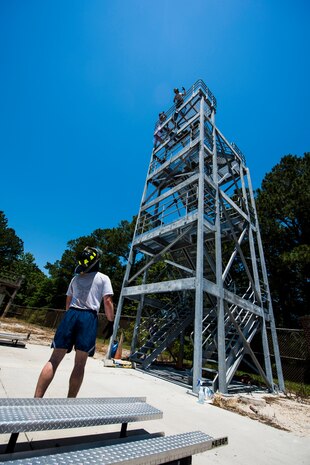 A member of the 628th Security Forces Squadron team pulls a fire hose to the top of the five-story fire training tower during the Police Week Guns and Hoses competition May 15, 2013, at Joint Base Charleston – Air Base, S.C. The 628th Security Forces Squadron hosted events including the "Guns and Hoses" fitness challenge, a shooting competition, chili cook-off and a retreat ceremony. National Police Week recognizes the services and sacrifices of U.S. law enforcement personnel.  (U.S. Air Force photo/ Senior Airman George Goslin)