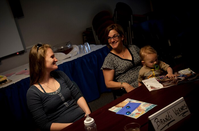 Brandi Varnes, wife of Staff. Sgt. Christopher Varnes, shares a laugh with Meighan Altwies, wife of Lt. Col. Aaron Altwies, as Altwies holds Varnes’ baby during the Military Spouse Appreciation Event May 16, 2013, at Joint Base Charleston – Air Base, S.C. The event was meant to be a day of recognizing military spouses for their important support roles as well as giving them recognition for the sacrifices they make every day. (U.S. Air Force photo / Airman 1st Class Tom Brading)