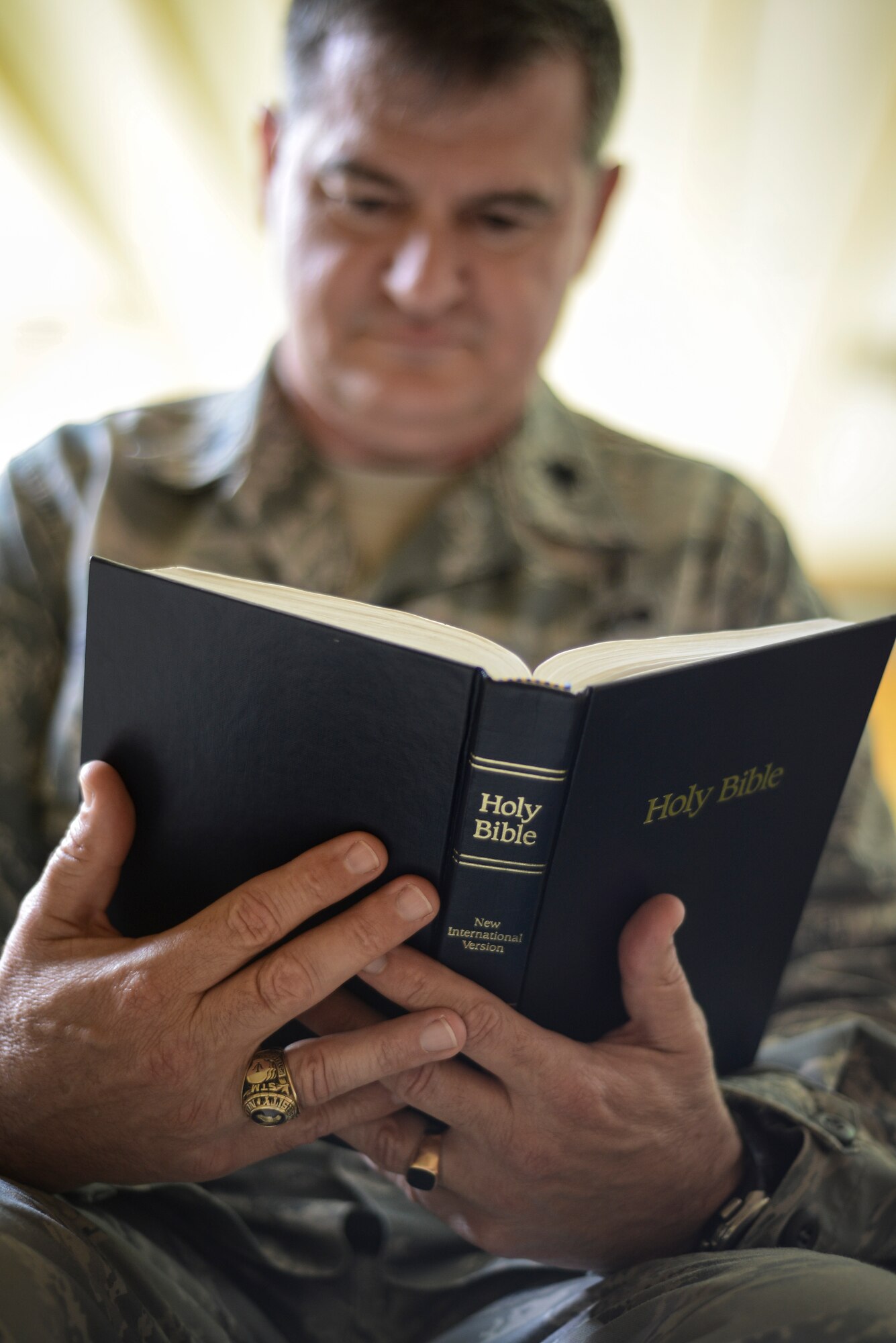 Chaplain (Lt. Col.) John Tillery, reads the Bible in a pew at the Aviano Air Base Chapel in Italy May 15, 2013. Once Tillery learned to read in the third grade, he was able to use reading as an escape from his violent home life. (U.S. Air Force photo/Staff Sgt. Katherine Tereyama)