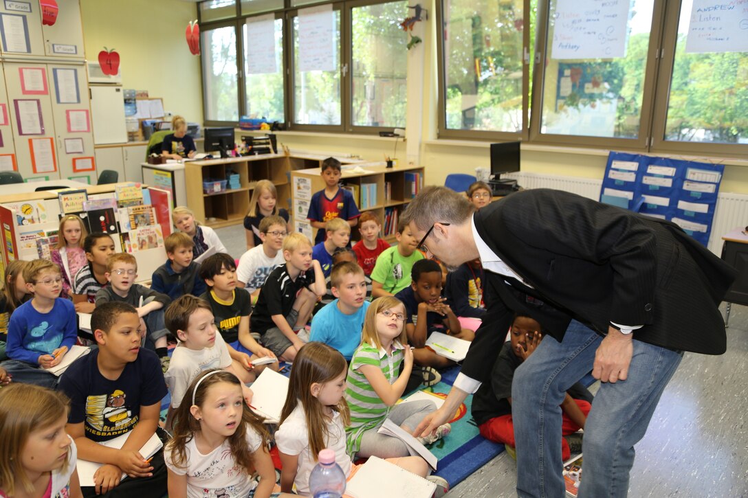 Department of Defense Education Activity Europe’s Aukamm Elementary students learn about the ‘Science behind the Magic’ from Brian Temple, Europe District Public Affairs chief, as part of the U.S. Army Corps of Engineers’ STEM educational outreach program May 10, 2013 in Wiesbaden, Germany. Temple demonstrated magic tricks using rope, coins and flash paper and explained the science and technology behind the production of these magic props. Flash paper, which Temple lit on fire and turned into a $100 bill, generated excitement from the student audience. The paper is developed through a special scientific process, allowing it to burn brightly.  Temple used student excitement about magic to reveal the science and technology that supports the art. USACE is working, as an organization, to engage young students early and be a constant STEM resource throughout their educational career. According to statistics, a U.S. student must decide by eighth-grade if they wish to pursue a career in STEM fields. Elementary school is not too young to introduce students to science, technology, engineering and math opportunities and get them thinking about their future. 