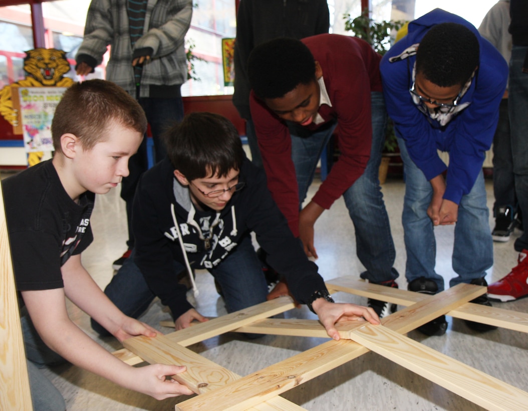 In honor of National Engineers Week 2013 U.S. Army Corps of Engineers Europe District employees present structural engineering, alternative energy and fire protection topics to Wiesbaden Middle School students Feb. 19-21 in Wiesbaden, Germany. Brit Rockafellow and James Hogenson, district fire protection engineers, presented to 8th grade science students on the concept of the Fire Triangle. They demonstrated the requirement of oxygen, heat and fuel to create a fire. They also explained their role in determining the proper interior finishes, fire alarm system and proper exiting when working on projects for USACE.  The lessons provided a forum for volunteers to come into the school and expose the students to real-world applications of what they learn in the classroom as it relates to science, technology, engineering and math or STEM. (U.S. Army Corps of Engineers photo by Jennifer Aldridge)        