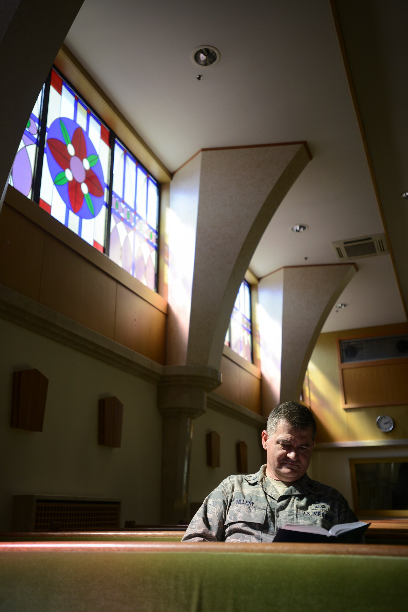 Chaplain (Lt. Col.) John Tillery, reads the Bible in a pew at the Aviano Air Base Chapel in Italy May 15, 2013. While Tillery is a successful man now, he had a difficult upbringing as a child and didn’t learn to read until he was in the third grade. (U.S. Air Force photo/Staff Sgt. Katherine Tereyama)