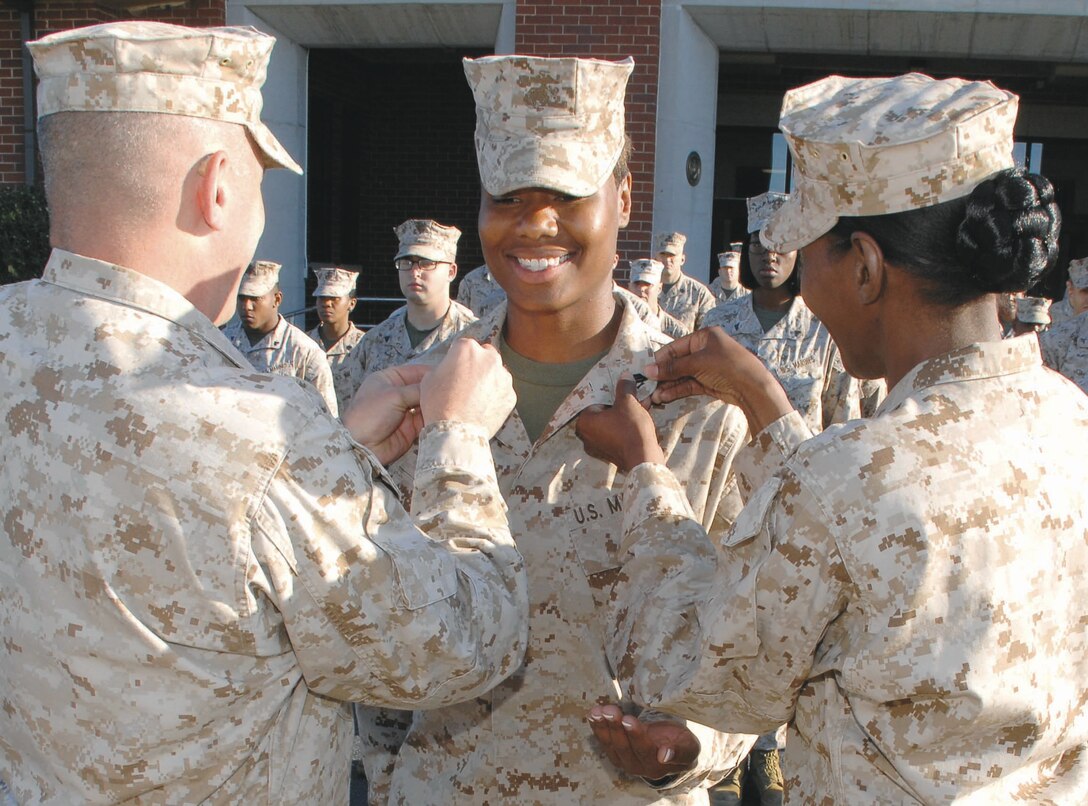 Sgt. Stephanie A. Bowens, postal clerk, Base Mailroom, Marine Corps Logistics Base Albany, has her new sergeant chevrons pinned on by Col. Donald J. Davis, left, commanding officer, MCLB?Albany, and Master Gunnery Sgt. Carlotta M. Moore, adjutant chief, Marine Corps Logistics Command, during a ceremony held in front of Building 3500, here, May 13.