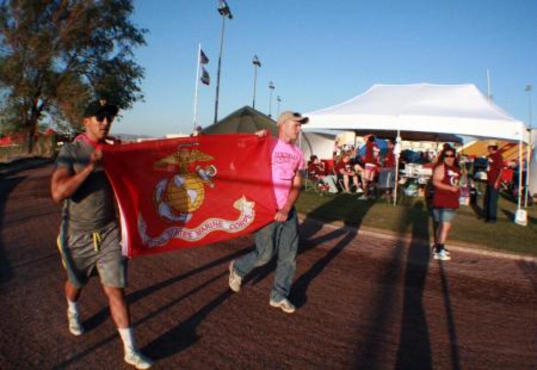(Left to right) Private First Class Adrian Velasco and Staff Sgt. Jeffery Worley, Marines with Marine Corps Logistics Base Barstow and members of team Desert Rat, carry the Marine Corps flag as they walk a lap during the 16th annual Relay for Life of Barstow held at Barstow High School, May 18.
