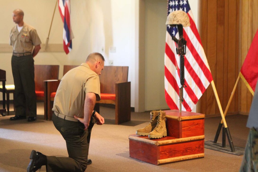 Colonel Joseph Russell, the commanding officer of Headquarters Battalion, 1st Marine Division, pays his respects to fallen Cpl. Benjamin J. Gardner, a motor transportation operator serving with Truck Company Alpha, Headquarters Battalion, at a memorial ceremony here, May 22, 2013. Gardner, 25, from Fort Wayne, Ind., was suffering from a disorder that affected his nervous system.