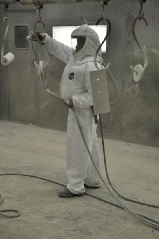 Yvonne Rivera, a painter on the Yermo Annex of Marine Corps Logistics Base Barstow, spray paints parts on an M917 dump truck, May 15. Rivera is using techniques she acquired through the Iowa Waste Reduction Center’s Spray Technique and Research for Defense program to accomplish her mission as effectively as possible.
