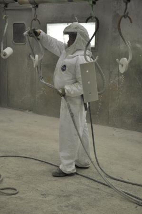 Yvonne Rivera, a painter on the Yermo Annex of Marine Corps Logistics Base Barstow, spray paints parts on an M917 dump truck, May 15. Rivera is using techniques she acquired through the Iowa Waste Reduction Center’s Spray Technique and Research for Defense program to accomplish her mission as effectively as possible.
