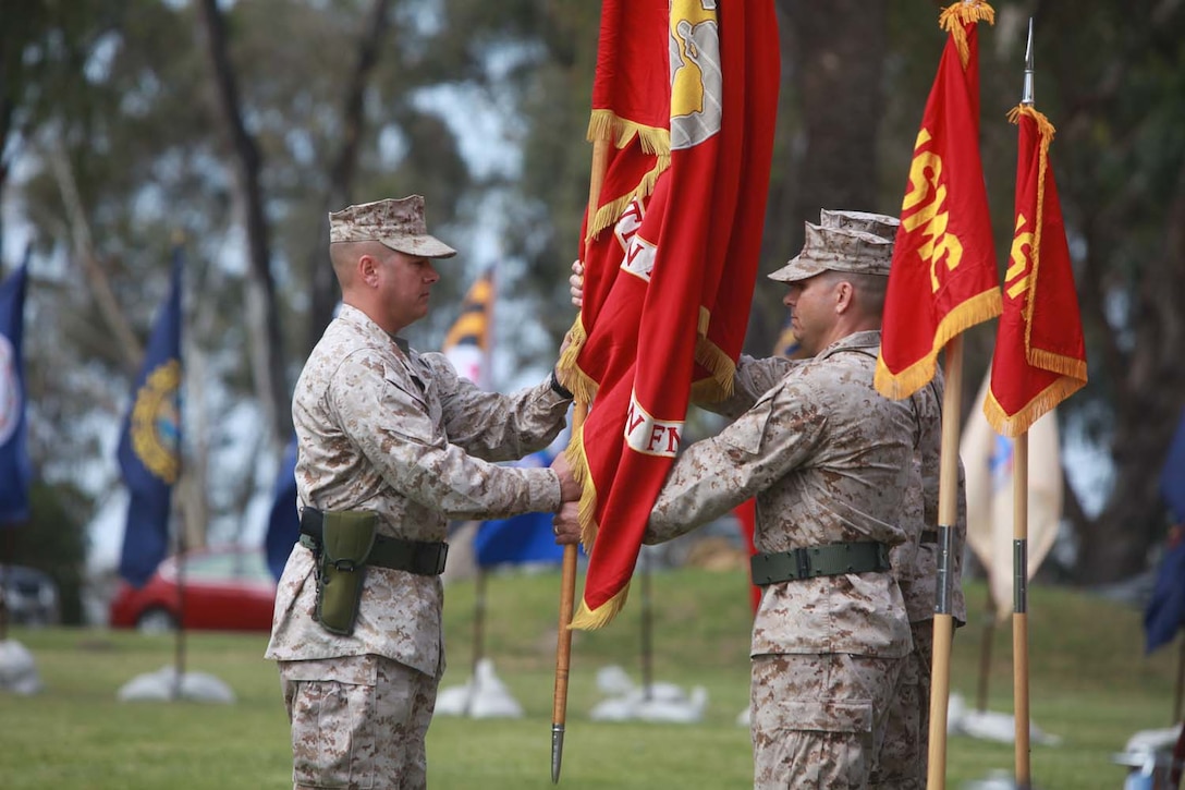 Lt. Col. Matthew R. Simmons, incoming commanding officer of 9th Communications Battalion, I Marine Expeditionary Force Headquarters Group, receives the guidon during a change of command ceremony at Camp Pendleton, Calif., May 23. Simmons relieved Lt. Col. Ahmed T. Williamson as the commanding officer of 9th Comm. Bn., and received the unit's guidon to commence his duties.