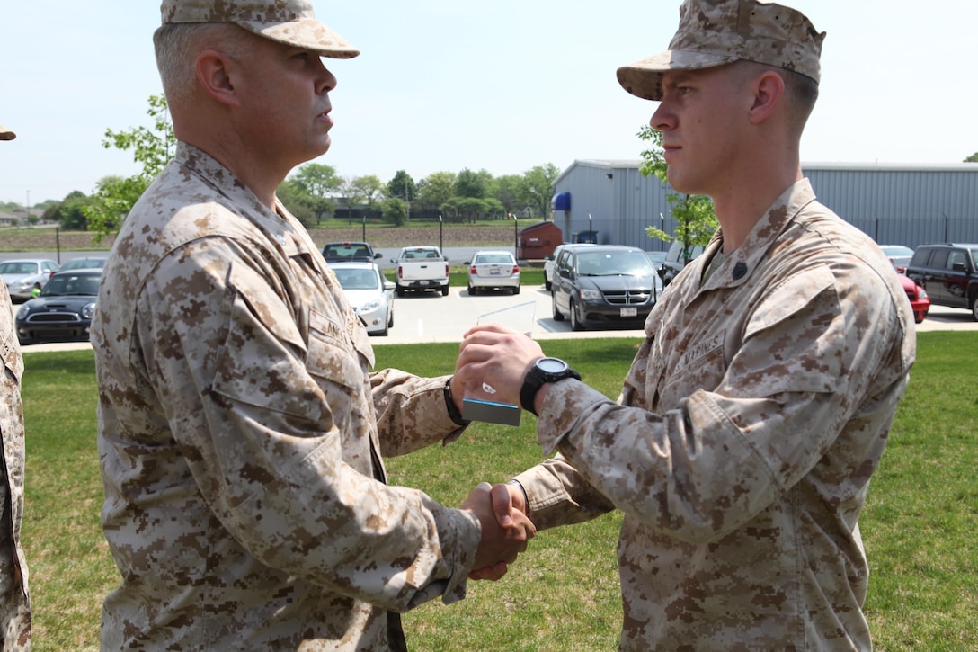 The 4th Reconnaissance Battalion commander, Lt.  Col. Dion A. Anglin, presents Staff Sgt. Alec Haralovich with the Gunnery Sgt. John Basilone Award for Courage and Commitment during a ceremony here, May 19, 2013. Anglin, who is from Warshaw, Ind., traveled from his San Antonio-based unit headquarters to bestow Haralovich with the honor. Harolovich,who is from Bloomington, Ind.,  is currently assigned to Company E, a section assign to Anglin. 