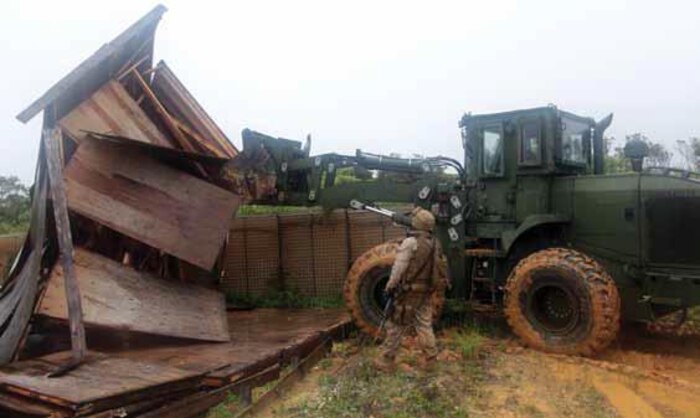 Cpl. Ryan D. Jones guides a front-end loader as it destroys a simulated forward operating base during a three-day predeployment field training exercise May 17 at the Central Training Area near Camp Hansen. This training allows Marines to use hands-on techniques previously learned in a classroom setting to ensure they understand how to demilitarize forward operating bases. Jones is a heavy-equipment operator with Company F, 9th Engineer Support Battalion, 3rd Marine Logistics Group, III Marine Expeditionary Force.
