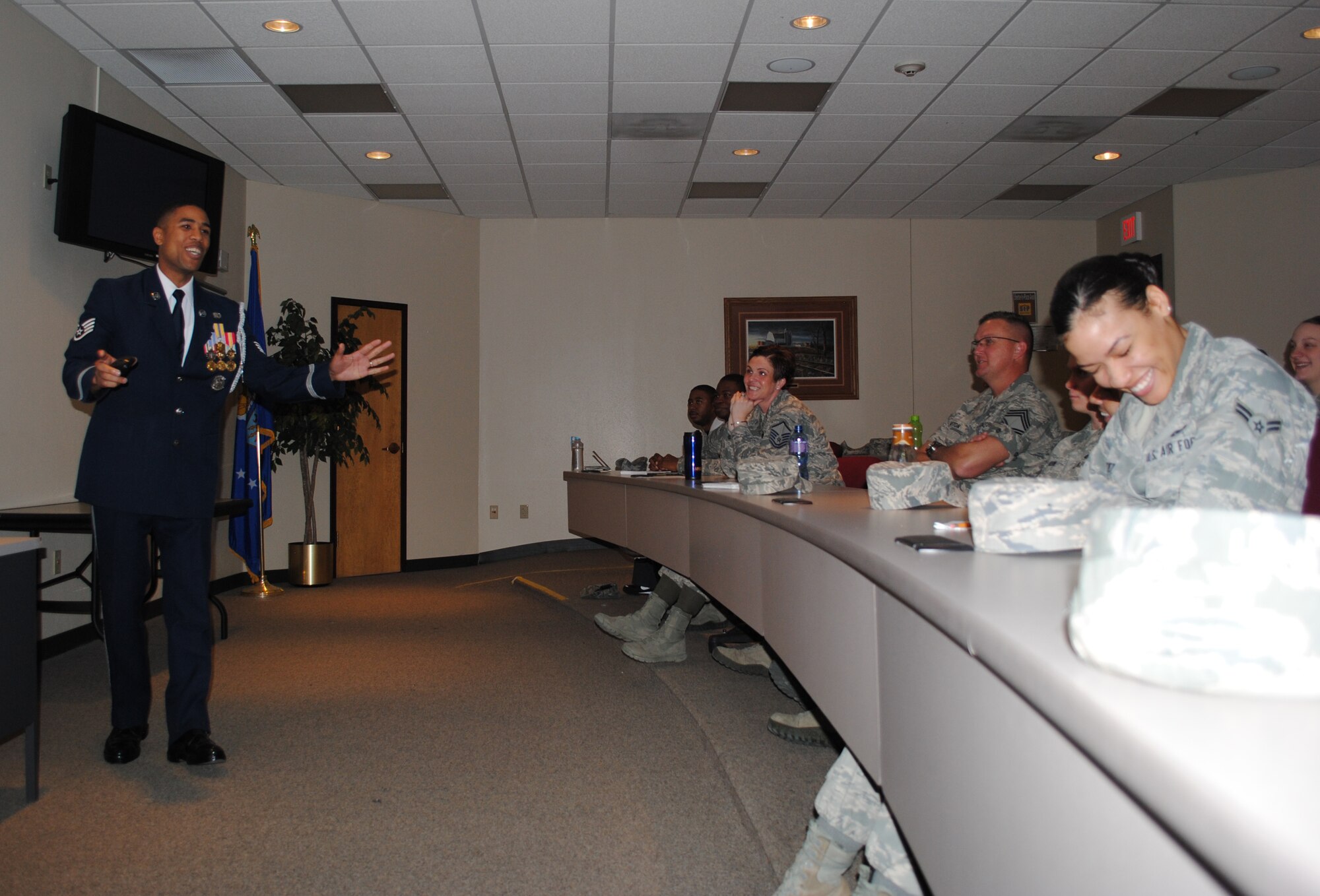 Staff Sgt. Andre Butler, causes one female Airman and a few others to chuckle after one of his stories as member of the U.S. Air Force Honor Guard. The NCO in charge of the Air Force Honor Guard technical training school at Joint Base Anacostia-Bolling, Washington, D.C., spoke to 30 Airmen attending a briefing about Air Force special duties, which took place May 17, 2013, at the base education center on Grand Forks Air Force Base, N.D.  (U.S. Air Force photo/Staff Sgt. Luis Loza Gutierrez)
