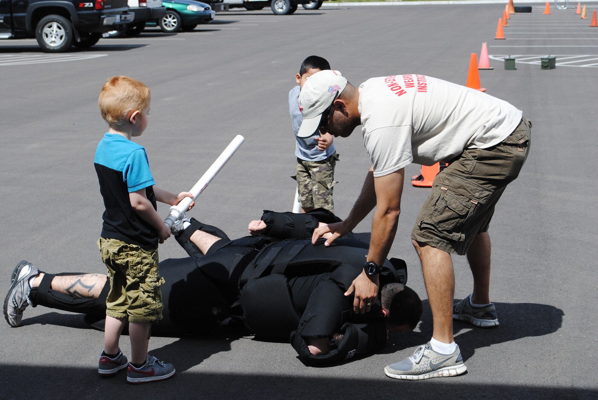 Tech. Sgt. Marcus Serrano, 341st Security Support Squadron member, pretends to handcuff Staff Sgt. Maxwell Thompson, 341st SSPTS member, after children helped get him on the ground during a security forces demonstration at the Base Exchange on May 12.  In celebration of National Police Week, members from Malmstrom’s Tactical Response Force, Convoy Response Force and K-9 Team were all at the demonstration showing viewers what they’re trained to do.  (U.S. Air Force photo/Senior Airman Cortney Paxton)