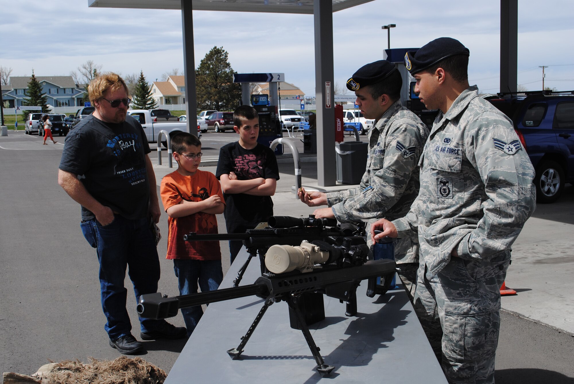 Senior Airmen Andre Davis (right) and Matthew Dubon, both 741st Missile Security Forces Squadron Tactical Response Force members, show Darrell Stegman and his grandsons a few weapons TRF members use during a demonstration at the Base Exchange on May 12.  The demonstration was one event of several that were held in celebration of National Police Week on Malmstrom Air Force Base on May 12 through 18.  (U.S. Air Force photo/Senior Airman Cortney Paxton)